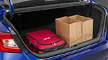 A picture from behind the vehicle showing the plentiful 2022 Honda Accord trunk space filled with a red suitcase and brown grocery bags.