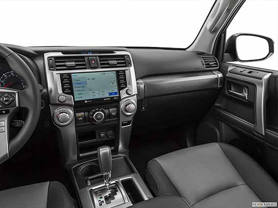 A picture taken from above a Toyota 4Runner's center console, looking at the shift knob, display screen and passenger side leg room area.