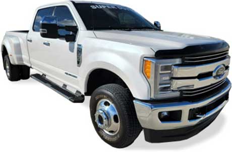 A picture of a white, 2019 Ford F350 Dually Lariat pickup truck taken from a passenger side front quarter angle
